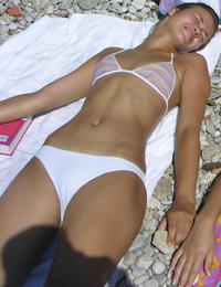 A busty bikini lady undressing on the Natadola Image 1